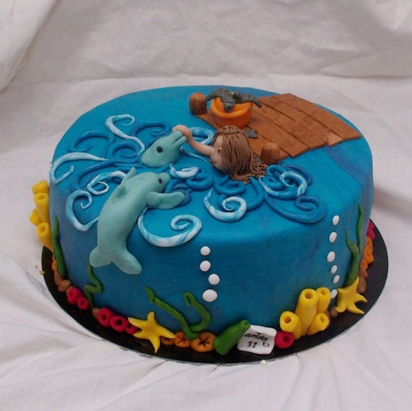 taart met dolfijnen en zwemmend meisje zwemmen met dolfijnen