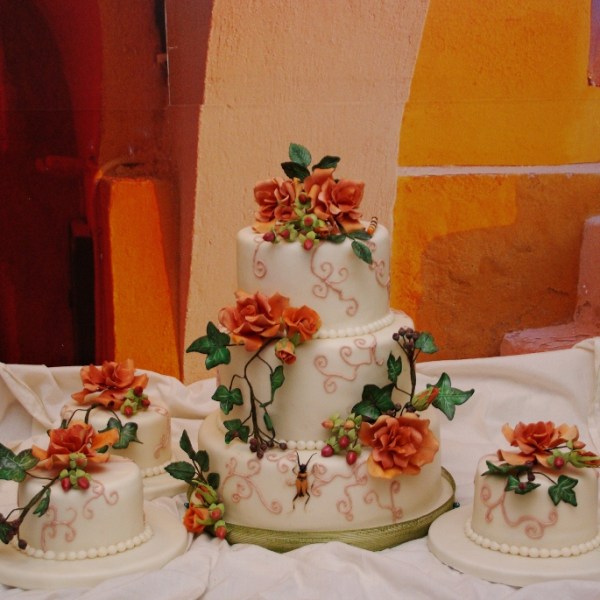 bruidstaart met gumpaste herfst bloemwerk en bijpassende minitaartjes