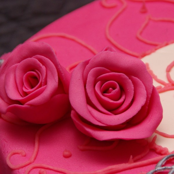roze roosjes op roze chocolade taart
